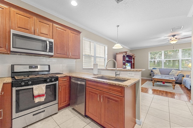 168 Canterbury Pl, Royal Palm Beach, FL 33414 - kitchen with appliances with stainless steel finishes, light tile patterned floors, a peninsula, crown molding, and open floor plan