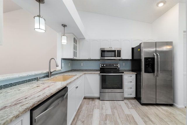 9904 Summerbrook Ter Unit C, Boynton Beach, FL 33437 - kitchen with appliances with stainless steel finishes, vaulted ceiling, light stone counters, white cabinetry, and light wood-type flooring