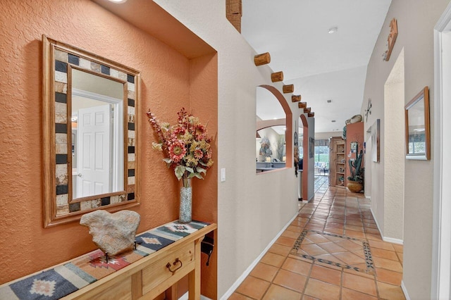9484 Swansea Ln, West Palm Beach, FL 33411 - corridor featuring light tile patterned floors, a textured wall, and arched walkways