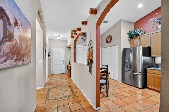 9484 Swansea Ln, West Palm Beach, FL 33411 - hall featuring arched walkways, light tile patterned flooring, and a textured wall