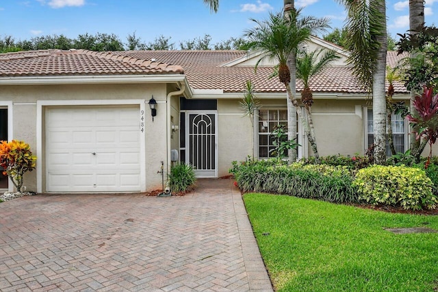 9484 Swansea Ln, West Palm Beach, FL 33411 - view of front of house with stucco siding, a tile roof, decorative driveway, and a front lawn