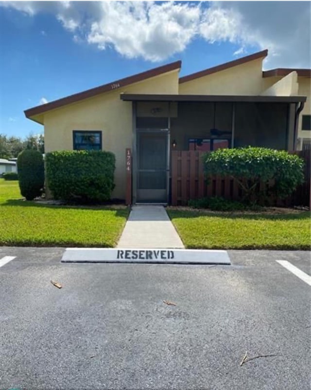 1764 W Sanderling 1 Ln Unit 1, Fort Pierce, FL 34982 - view of front of property featuring stucco siding, a front yard, and uncovered parking