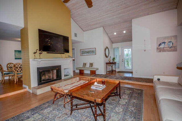 45 Birch Pl, Tequesta, FL 33469 - living room featuring wood finished floors, a fireplace with raised hearth, wooden ceiling, and high vaulted ceiling