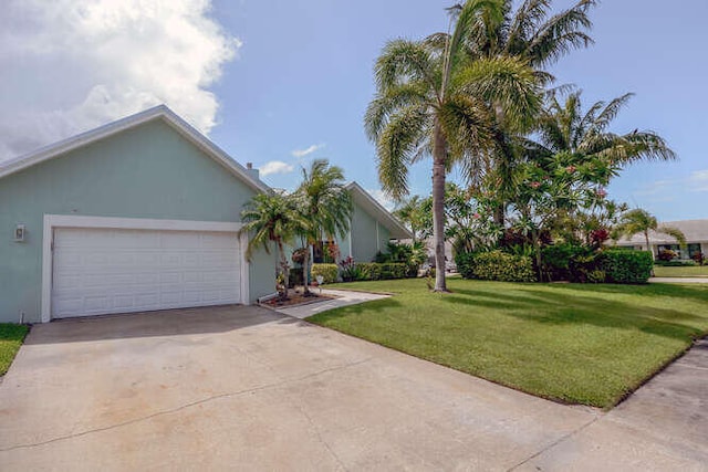 45 Birch Pl, Tequesta, FL 33469 - view of front of home featuring a front yard, concrete driveway, an attached garage, and stucco siding