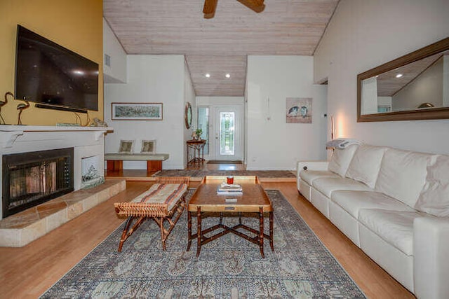 45 Birch Pl, Tequesta, FL 33469 - living area with lofted ceiling, wood ceiling, wood finished floors, a fireplace, and a ceiling fan