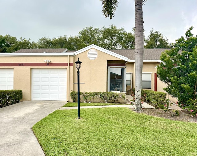 4561 Discovery Ln Unit 14, West Palm Beach, FL 33417 - view of front of home featuring driveway, a front lawn, stucco siding, and an attached garage