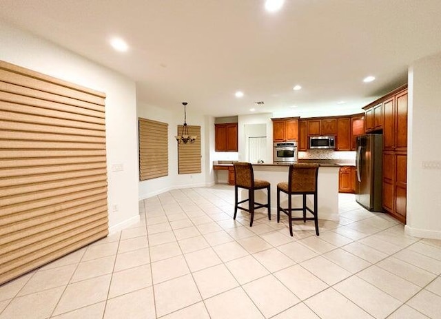 17464 SW 47th Ct, Miramar, FL 33029 - kitchen featuring appliances with stainless steel finishes, a kitchen breakfast bar, recessed lighting, light tile patterned floors, and a center island