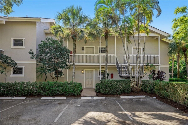 11863 Wimbledon Cir Unit 438, Wellington, FL 33414 - view of property with uncovered parking and stairs