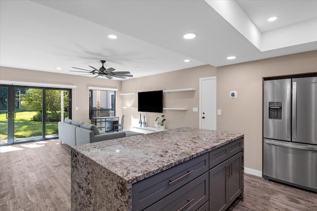 11863 Wimbledon Cir Unit 438, Wellington, FL 33414 - kitchen with stainless steel fridge with ice dispenser, wood finished floors, light stone counters, ceiling fan, and recessed lighting