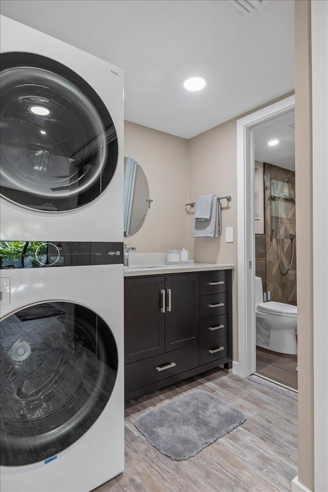 11863 Wimbledon Cir Unit 438, Wellington, FL 33414 - laundry room with stacked washer / dryer and light wood-type flooring
