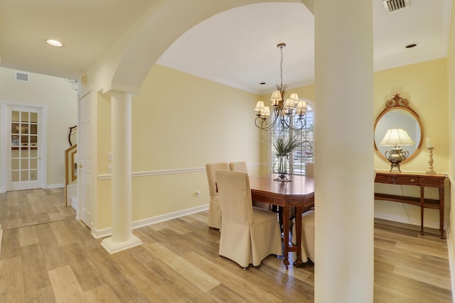 2000 SW Oakwater Pt, Palm City, FL 34990 - dining room featuring ornate columns, arched walkways, light wood-style flooring, a chandelier, and ornamental molding