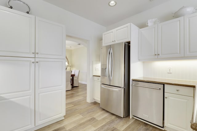2000 SW Oakwater Pt, Palm City, FL 34990 - kitchen with appliances with stainless steel finishes, arched walkways, light wood-style flooring, white cabinets, and recessed lighting