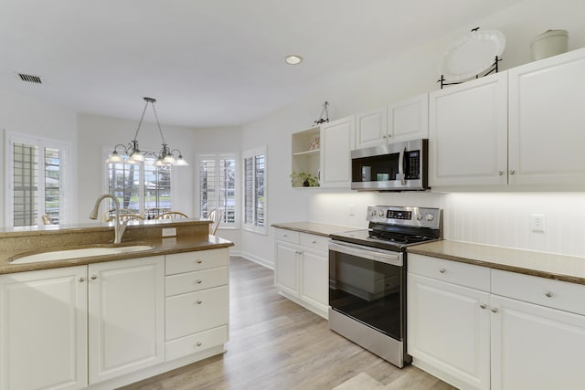 2000 SW Oakwater Pt, Palm City, FL 34990 - kitchen with stainless steel appliances, open shelves, light wood finished floors, white cabinets, and recessed lighting