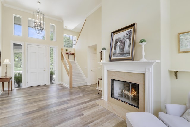 2000 SW Oakwater Pt, Palm City, FL 34990 - foyer featuring stairway, crown molding, light wood-style flooring, a chandelier, and a high ceiling
