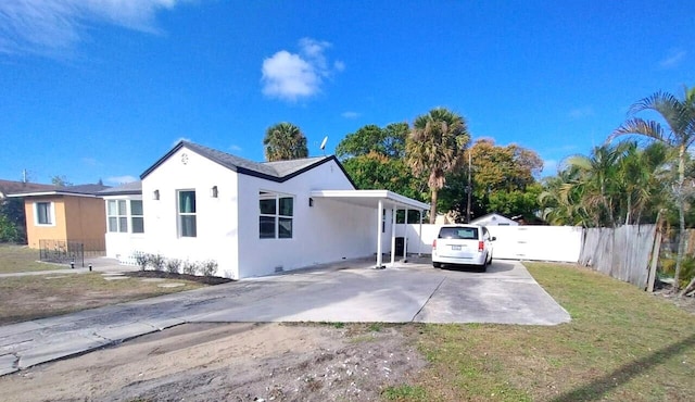 701 37th St, West Palm Beach, FL 33407 - view of side of property with concrete driveway, stucco siding, and an attached carport