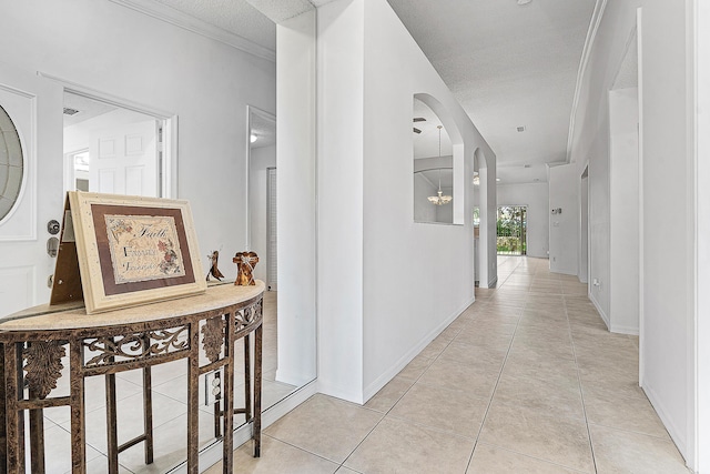 9331 Bridgeport Dr, Royal Palm Beach, FL 33411 - hall with light tile patterned floors, arched walkways, crown molding, and a textured ceiling