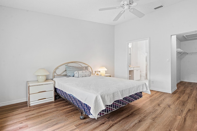 9331 Bridgeport Dr, Royal Palm Beach, FL 33411 - bedroom featuring wood finished floors, a spacious closet, ensuite bath, a closet, and a ceiling fan