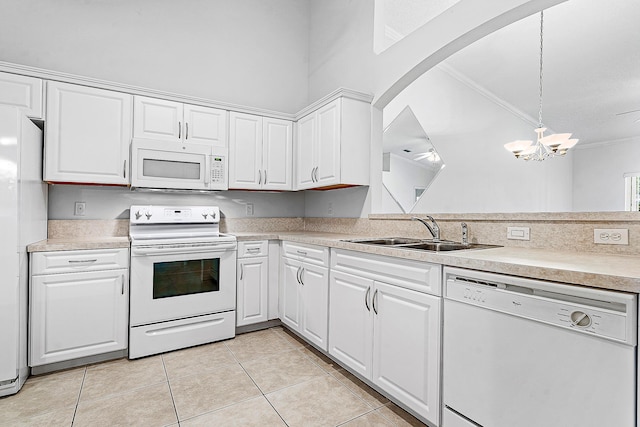 9331 Bridgeport Dr, Royal Palm Beach, FL 33411 - kitchen with white appliances, light tile patterned floors, light countertops, white cabinetry, and crown molding