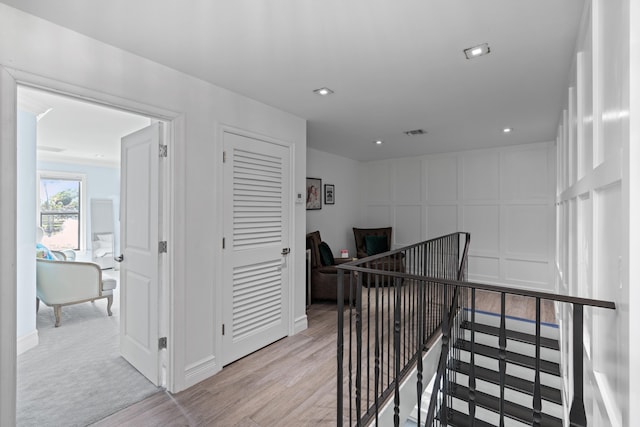 6204 Celadon Cir, Palm Beach Gardens, FL 33418 - hallway featuring a decorative wall, light wood-style floors, an upstairs landing, an office area, and recessed lighting