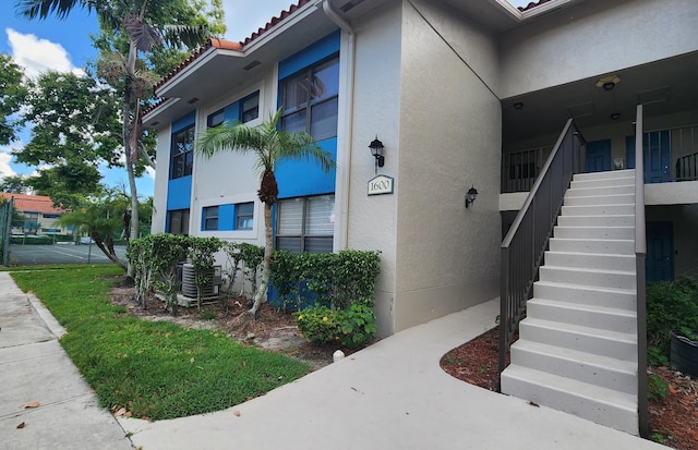 1600 Balfour Point B Dr Unit B, West Palm Beach, FL 33411 - view of side of home with stairs, stucco siding, and a tile roof