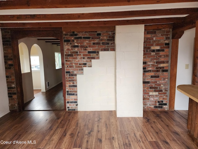 345 E Jefferson, Priest River, ID 83856 - unfurnished room with arched walkways, wood finished floors, and beam ceiling