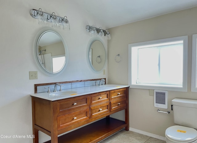 345 E Jefferson, Priest River, ID 83856 - bathroom featuring heating unit, double vanity, toilet, tile patterned flooring, and baseboards