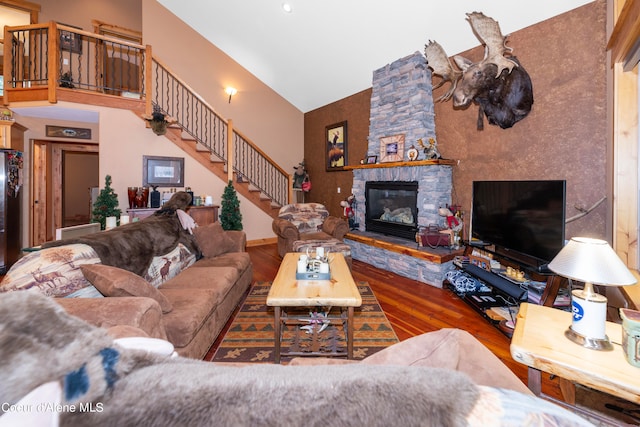 living room with dark wood-type flooring, high vaulted ceiling, and a fireplace