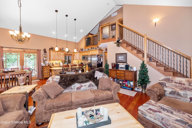 living room with an inviting chandelier, high vaulted ceiling, and light hardwood / wood-style flooring