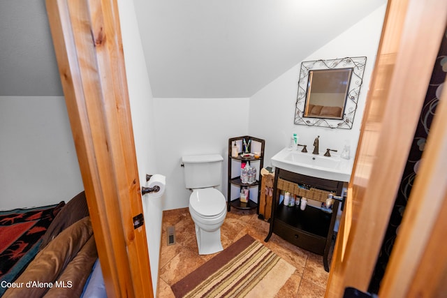 bathroom with toilet, tile floors, vaulted ceiling, and vanity