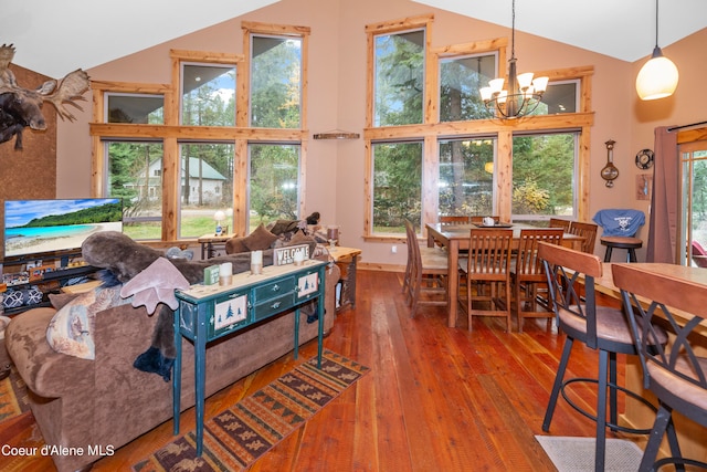 living room featuring high vaulted ceiling, dark hardwood / wood-style floors, and an inviting chandelier