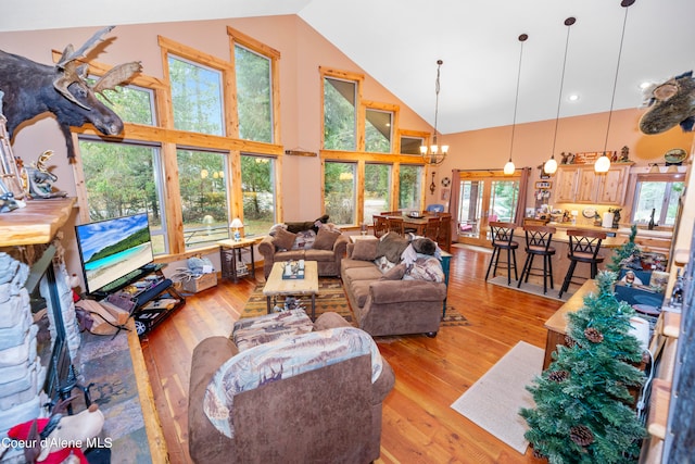 living room with high vaulted ceiling, french doors, a chandelier, and light wood-type flooring