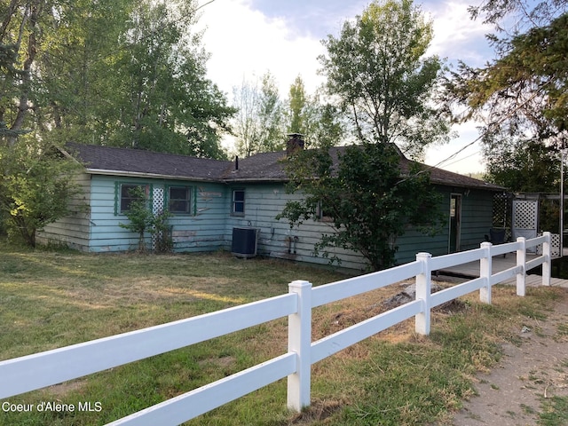 view of front of house featuring a front lawn and central AC unit