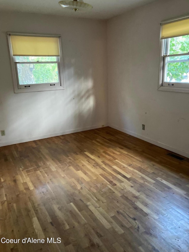 unfurnished room featuring hardwood / wood-style floors and plenty of natural light