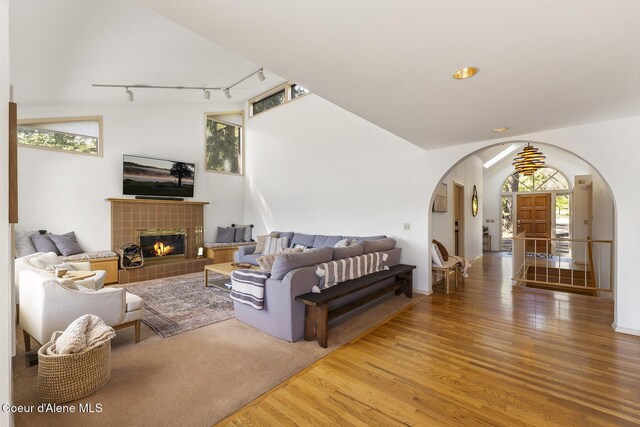 2772 W Lutherhaven Rd, Coeur Dalene, ID 83814 - living area with track lighting, a tiled fireplace, wood finished floors, and arched walkways
