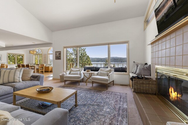 2772 W Lutherhaven Rd, Coeur Dalene, ID 83814 - living area featuring a tile fireplace, a towering ceiling, a healthy amount of sunlight, and carpet floors