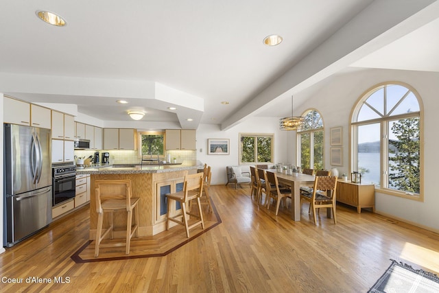 2772 W Lutherhaven Rd, Coeur Dalene, ID 83814 - kitchen with a breakfast bar, light wood-type flooring, recessed lighting, backsplash, and appliances with stainless steel finishes