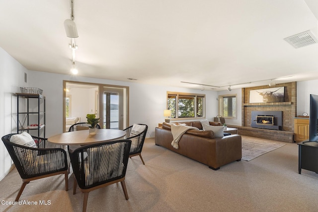 2772 W Lutherhaven Rd, Coeur Dalene, ID 83814 - dining space featuring rail lighting, visible vents, a fireplace, and light carpet