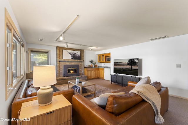 2772 W Lutherhaven Rd, Coeur Dalene, ID 83814 - living area with a fireplace, visible vents, light colored carpet, and track lighting