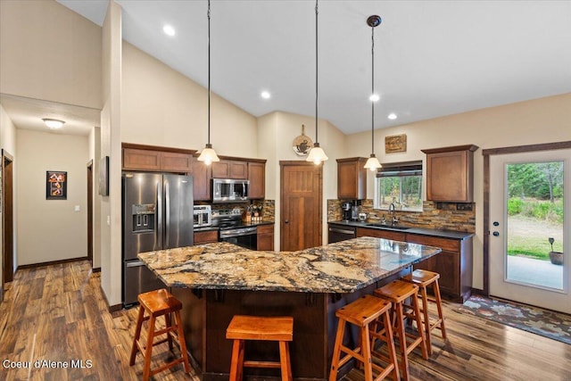 kitchen featuring a center island, high vaulted ceiling, dark hardwood / wood-style floors, and appliances with stainless steel finishes