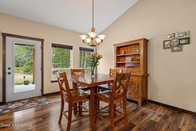 dining area with dark hardwood / wood-style flooring, lofted ceiling, and an inviting chandelier