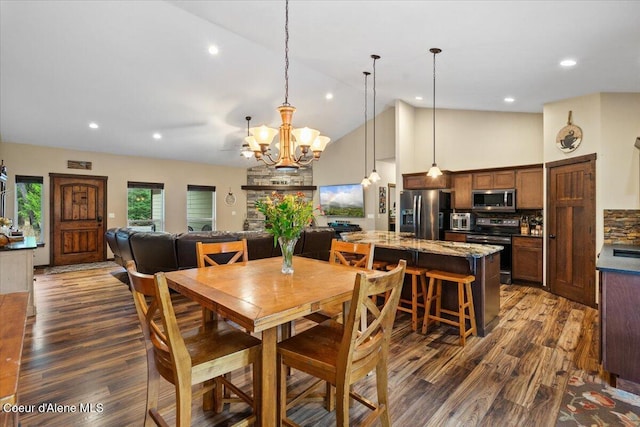 dining room with high vaulted ceiling, dark wood-type flooring, and an inviting chandelier