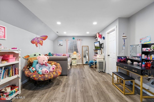 rec room featuring wood-type flooring, radiator heating unit, and lofted ceiling