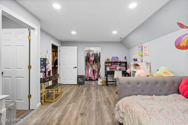 bedroom with hardwood / wood-style flooring, a closet, and lofted ceiling