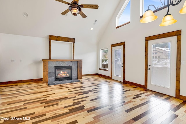 unfurnished living room with plenty of natural light, high vaulted ceiling, and light hardwood / wood-style flooring