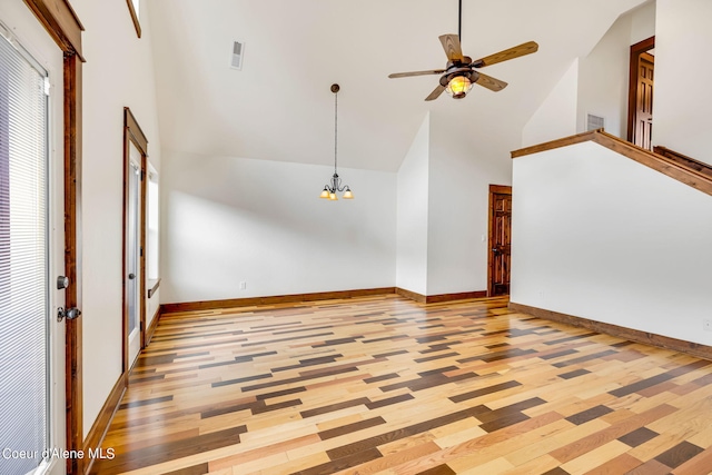 interior space featuring high vaulted ceiling, ceiling fan with notable chandelier, and light hardwood / wood-style flooring