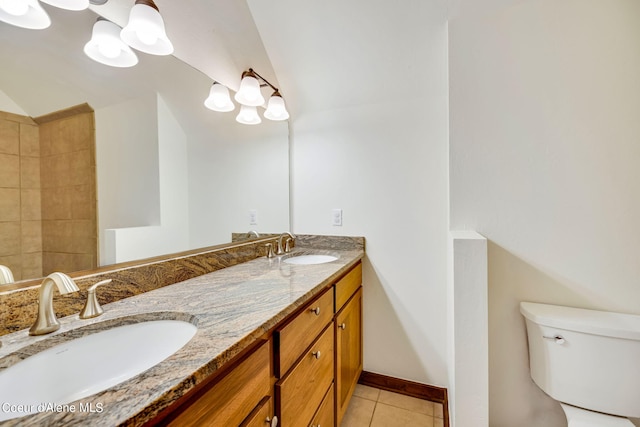 bathroom featuring toilet, dual vanity, and tile flooring