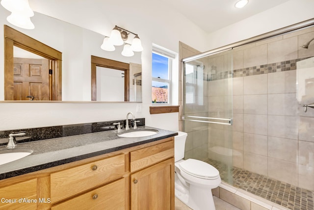 bathroom featuring toilet, vanity with extensive cabinet space, walk in shower, and double sink