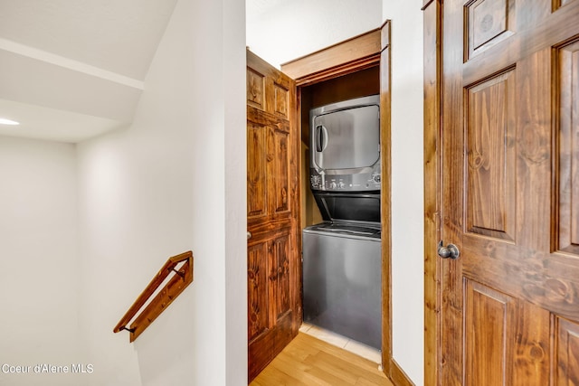 interior space with stacked washer / dryer and light hardwood / wood-style flooring