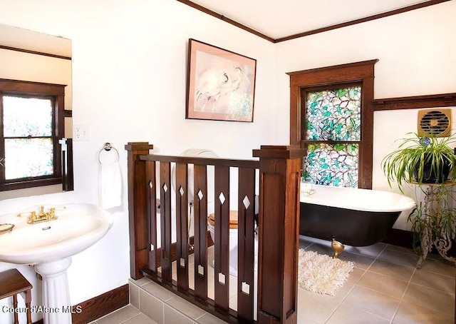 bathroom featuring tile flooring, a bathtub, and crown molding