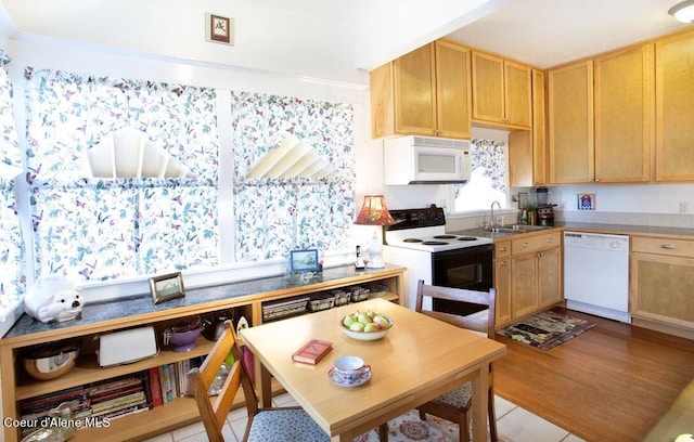 kitchen with white appliances, sink, and light tile flooring